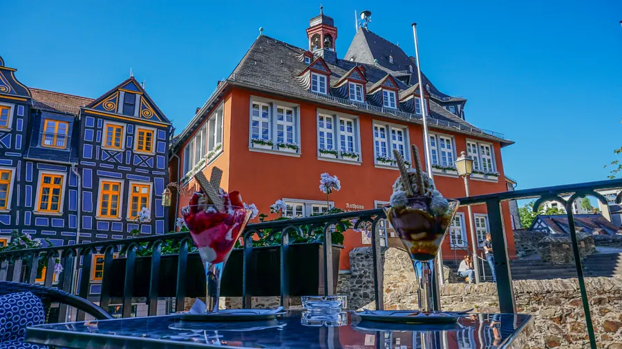 Blick vom Balkon auf das Idsteiner Rathaus und Fachwerkhäuser, vorne zwei Eisbecher auf dem Tisch