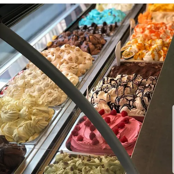 Eistheke mit vielen Sorten selbstgemachtem Eis, darunter Erdbeere, Schokolade und Pistazie