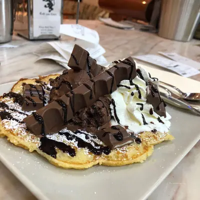 Waffel mit Schokoladenstücken, Sahne und Schokoladensoße
